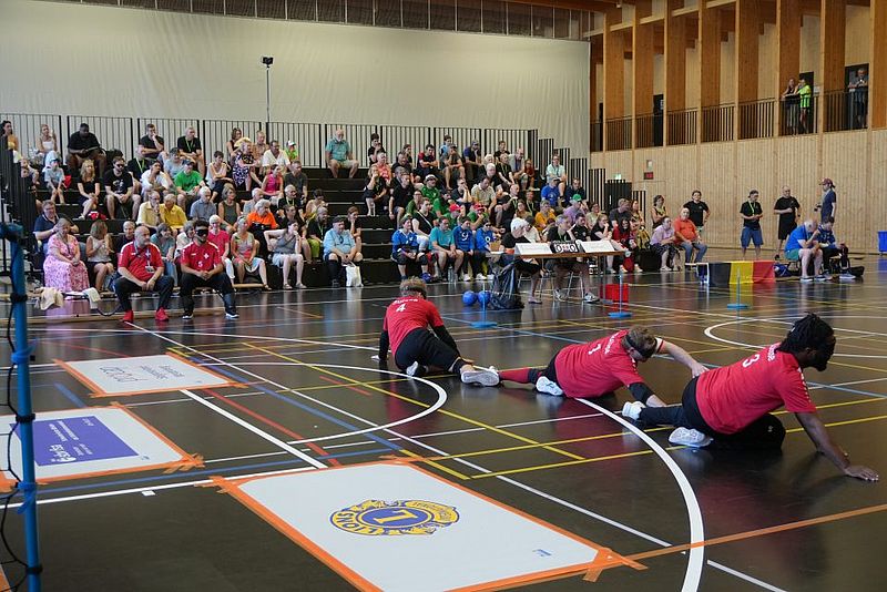 Drei Schweizer Torballer liegen in Verteidigungsposition vor dem Tor. Im Hintergrund ist die vollbesetzte Tribüne zu sehen.