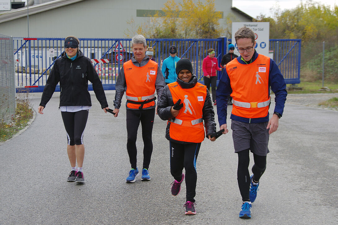 Blinde Läuferin mit Guide draussen beim Jogging