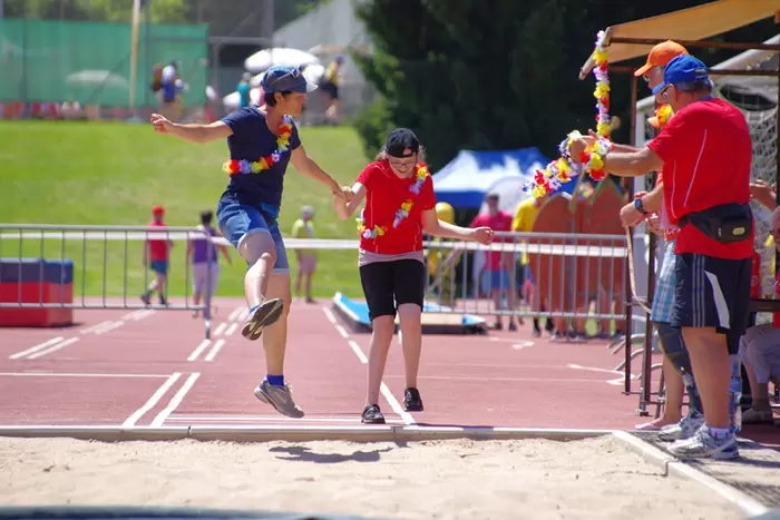 Leiterin mit Sportlerin beim Weitsprung