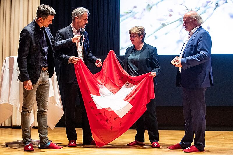 Übergabe der Schweizer Flagge mit allen Unterschriften der Athleten an Viola Amherd