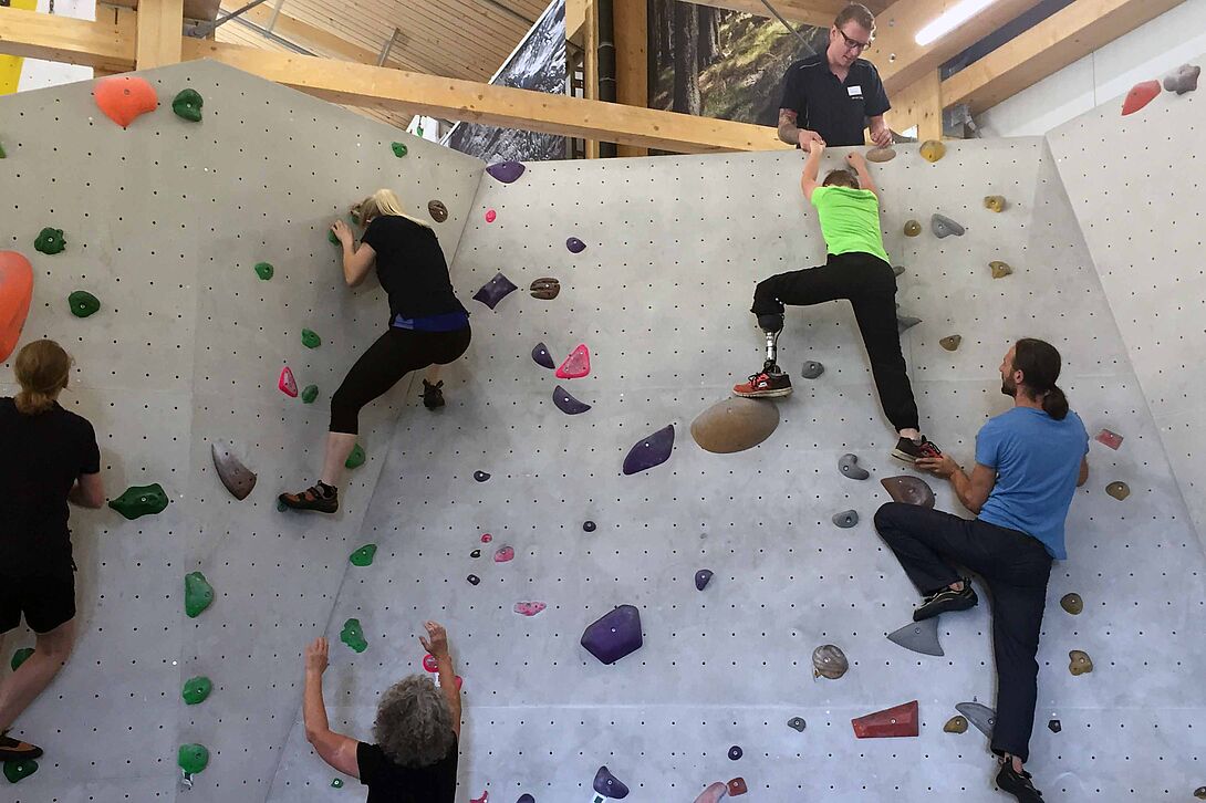 Adolescents et adultes avec différents handicaps pratiquent l’escalade sur blocs