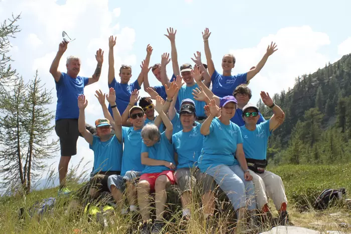 Eine Gruppe Wanderer ruht sich aus und winkt