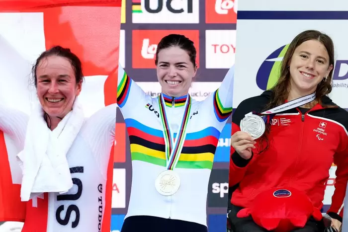 Drei Athletinnen stehen Seite an Seite, jede trägt eine Medaille und lächelt. Die mittlere Athletin trägt ein Trikot mit Regenbogenstreifen und eine Goldmedaille, die anderen tragen Silbermedaillen und Schweizer Teamkleidung. Sie stehen auf einem Podium mit Event-Kulissen.