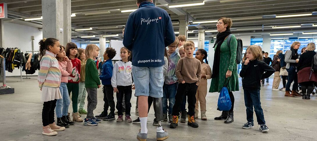 Schüler mit und ohne Behinderungen spielen mit den Lehrpersonen Unihockey