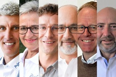 Ein zusammengesetztes Bild, das sechs Personen zeigt, die jeweils von den Schultern aufwärts fotografiert wurden und nebeneinander stehen. Die Gruppe umfasst sowohl Männer als auch Frauen, die alle lächeln, Brillen oder Kragenhemden tragen.
