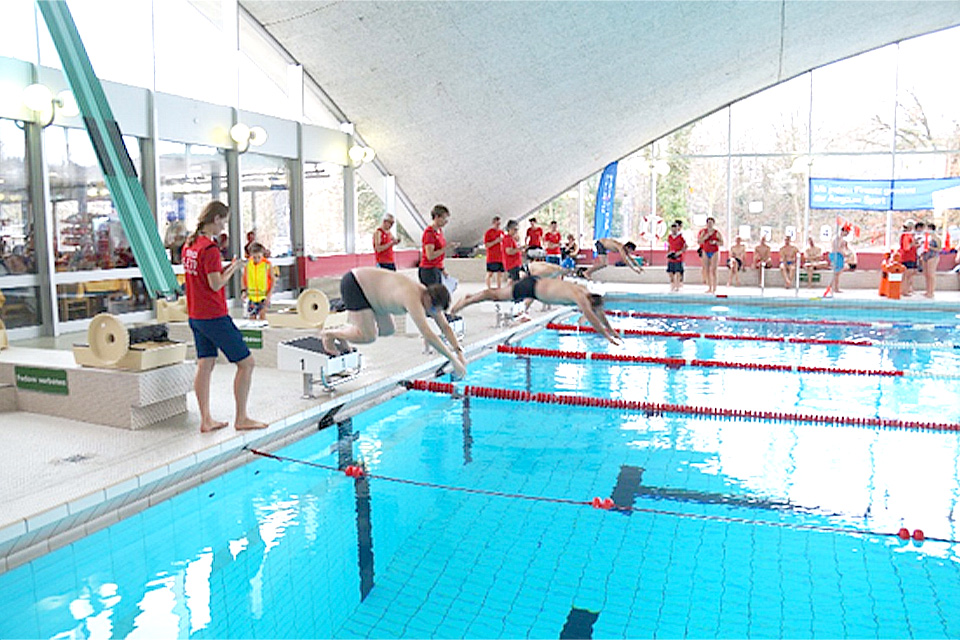 Teilnehmer tauchen im Pool ein