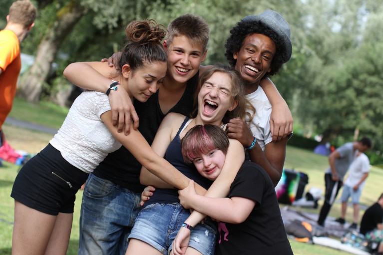 Des adolescents visiblement heureux dans le camp Cooltour sur la pelouse au bord de l’Aar 