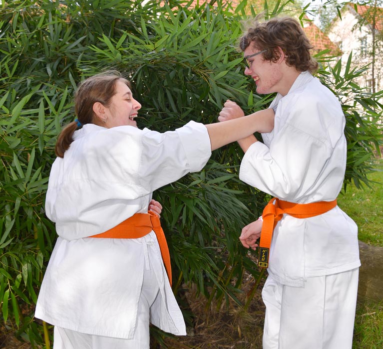 Die Karate-Sportler Nicole und Nino üben einen Karate-Griff