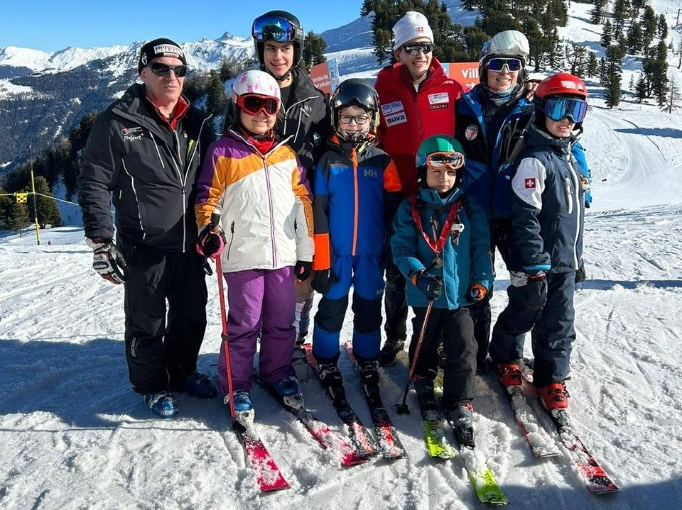 Théo Gmür (veste rouge) pose avec les enfants et leurs entraîneurs. De gauche à droite Dominique Fivaz, Julia, Aymeric, Jack, Ismaël, Marina Praz-Wicki et Henry.