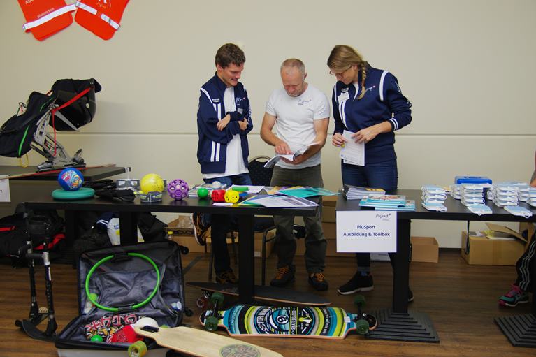 Unterstützung für die Clubs, von Sportgeräten bis zur Praxisberatung und noch vieles mehr Mitarbeiter von PluSport betreuen einen Stand mit Sportgeräten und -Material