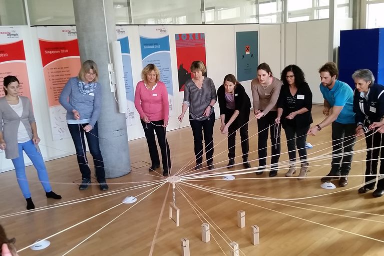 Die Services von PluSport spielen gut zusammen Eine Gruppe spielt das Kooperationsspiel Fröbelturm