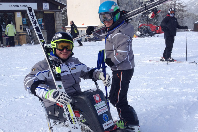 Ein sitzender Skifahrer und Rollstuhlsportler sowie eine stehende Skifahrerin mit Behinderung im Schnee